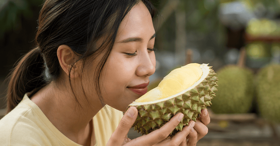 A woman smell a durian